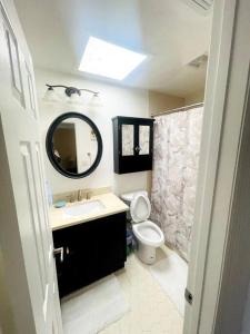 een badkamer met een wastafel, een toilet en een spiegel bij Modern Sun N’ Lake Villa - Self Check-In in Sebring