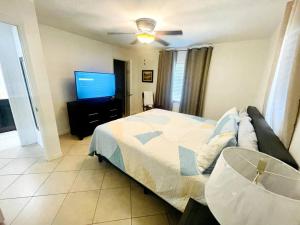 een slaapkamer met een bed en een flatscreen-tv bij Modern Sun N’ Lake Villa - Self Check-In in Sebring