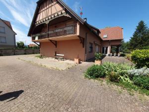 a house with a balcony on a brick road at Le Clos de Charlotte in Colmar