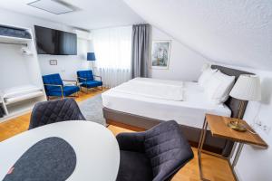 una camera d'albergo con letto, tavolo e sedie di City Apartments FN L7 KLIMATISIERT-mit Küche a Friedrichshafen