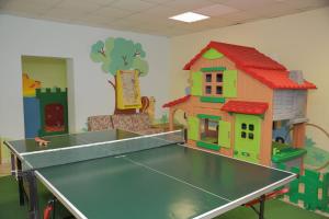 una sala giochi con tavolo e una casetta giocattolo di Hotel Malder a Soraga