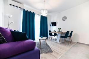 a living room with a purple couch and a table at Apartments MENA in Bibinje
