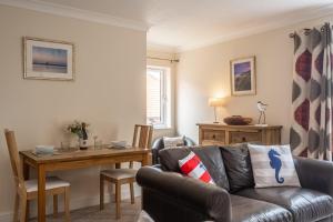 Avocet Apartment في ويلز نكست ذا سي: غرفة معيشة بها أريكة وطاولة