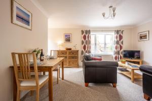 Avocet Apartment في ويلز نكست ذا سي: غرفة معيشة مع طاولة طعام وأريكة