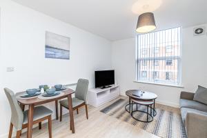a living room with a table and a couch at Winckley House Serviced Apartments in Preston in Preston