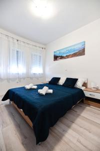 a bedroom with a large bed with two towels on it at Apartments MENA in Bibinje