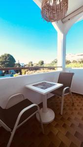 a white table and chairs in a room with a window at Angelos Studios No 3-4 in Faliraki