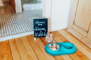 a dog bowl and a sign on a wooden floor at The Francis Hotel in Portland