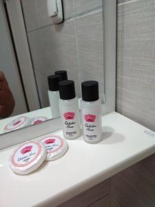 - un comptoir de salle de bains avec 3 bouteilles de cosmétiques dans l'établissement Orhidea House, à Ohrid