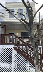 a house with a wooden deck and a tree at Cozy Bay Home Beach+Casino+More in Atlantic City