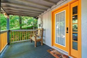 a porch with an orange door and a chair at NEW Cabin with Spectacular View with HOT TUB in the Smoky MTNS in Sevierville