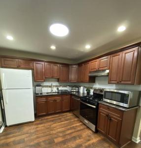 a kitchen with wooden cabinets and a white refrigerator at Cozy Bay Home Beach+Casino+More in Atlantic City