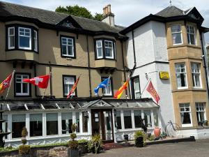 a building with flags on the front of it at Strathpeffer Hotel in Strathpeffer