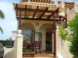 eine Veranda mit einer hölzernen Pergola auf einem Haus in der Unterkunft Casa Hermosa in Oliva