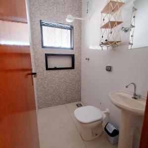 a bathroom with a toilet and a sink at Chácara do Mirante in São Sebastião do Paraíso