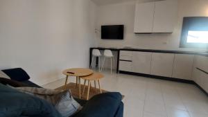 ein Wohnzimmer mit einem Sofa und einem Tisch in der Unterkunft Comodo per Venezia - Schissa apartment in Jesolo