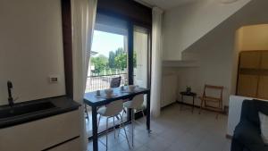 eine Küche mit einem Tisch und Stühlen sowie einem Fenster in der Unterkunft Comodo per Venezia - Schissa apartment in Jesolo
