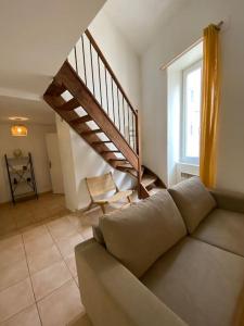 a living room with a couch and a staircase at Grand appartement jardins de la Fontaine in Nîmes
