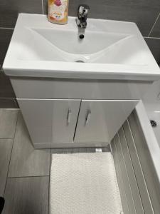 a bathroom with a white sink and a white rug at Stunning private room 2 in Bedford