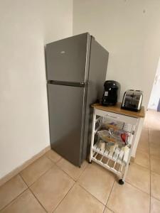 a stainless steel refrigerator in a kitchen with a cart at Grand appartement jardins de la Fontaine in Nîmes