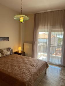 - une chambre avec un lit et une grande fenêtre dans l'établissement Lazaros family home, à Néa Michanióna