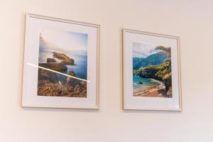duas fotografias emolduradas penduradas numa parede branca em Ocean View Flat em Câmara de Lobos