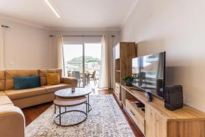 a living room with a couch and a tv at Ocean View Flat in Câmara de Lobos