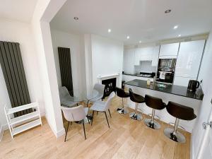 cocina con mesa de cristal y sillas en Massive Flat Near Greenwich Park( with office), en Londres