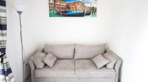 a couch in a living room with a painting on the wall at Irena Downtown Apartment in Budva