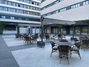 un patio avec des tables et des chaises en face d'un bâtiment dans l'établissement Hotel Pax Guadalajara, à Guadalajara