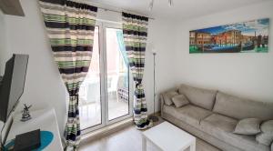 a living room with a couch and a large window at Irena Downtown Apartment in Budva