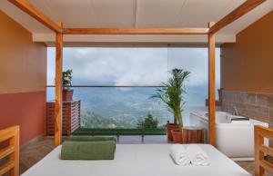 a bathroom with a large window with a tub and a sink at Club Himalaya, by ACE Hotels in Nagarkot