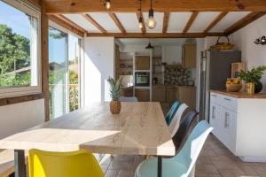 uma cozinha com uma mesa de madeira e cadeiras em Ocean Garden Surf Lodge em Capbreton