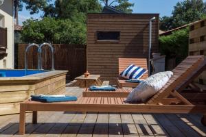a patio with a wooden bench next to a pool at Ocean Garden Surf Lodge in Capbreton