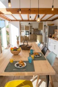 uma mesa de madeira com comida na cozinha em Ocean Garden Surf Lodge em Capbreton
