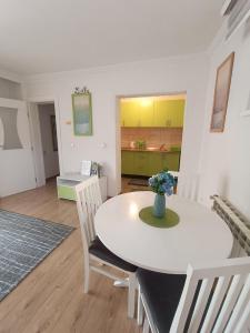 Enaa في سراييفو: مطبخ وغرفة طعام مع طاولة وكراسي بيضاء