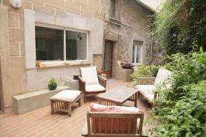 a patio with chairs and tables and a window at Maison avec jardin centre historique in Agde