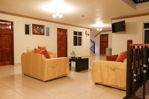ein Wohnzimmer mit 2 Sofas und einem TV in der Unterkunft Hotel Coroneo 