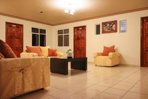 ein Wohnzimmer mit Sofas, einem Tisch und Stühlen in der Unterkunft Hotel Coroneo 