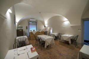 un restaurante con mesas y sillas y un chef en la cocina en Palazzo Sertorio Suites, en Gavi