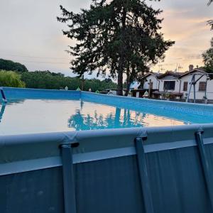 une grande piscine avec une clôture bleue dans l'établissement Masseria Le Querciole, à Fauglia