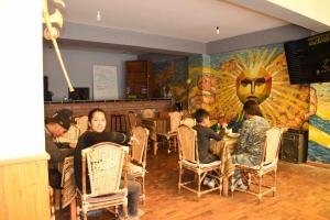 solsticio hostel في كوباكابانا: مجموعة من الناس يجلسون على طاولة في مطعم