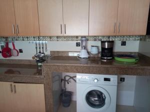 a kitchen with a washing machine under a counter at Appartement sselam fetouaki montagne view in Moulay Yacoub +7 photos