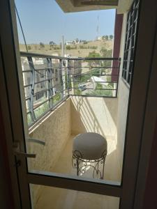 a chair sitting on a balcony with a window at Appartement abdessalam fetouaki in Moulay Yacoub