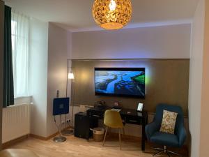 a room with a desk and a tv on a wall at Hôtel Vintage in Quimperlé