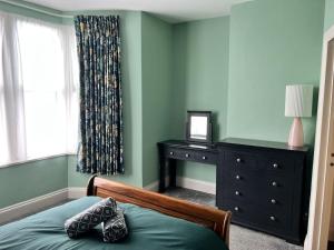 a bedroom with a bed and a dresser and a window at Ground floor flat in Keynsham