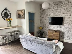 a living room with a couch and a brick wall at Ground floor flat in Keynsham