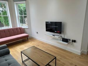 sala de estar con sofá y TV de pantalla plana en Massive Flat Near Greenwich Park( with office), en Londres