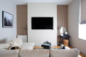 a living room with a couch and a flat screen tv at Eden Apartment - Islington - 2 bed with terrace in London