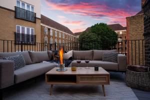 um pátio com um sofá e uma mesa com copos de vinho em Eden Apartment - Islington - 2 bed with terrace em Londres